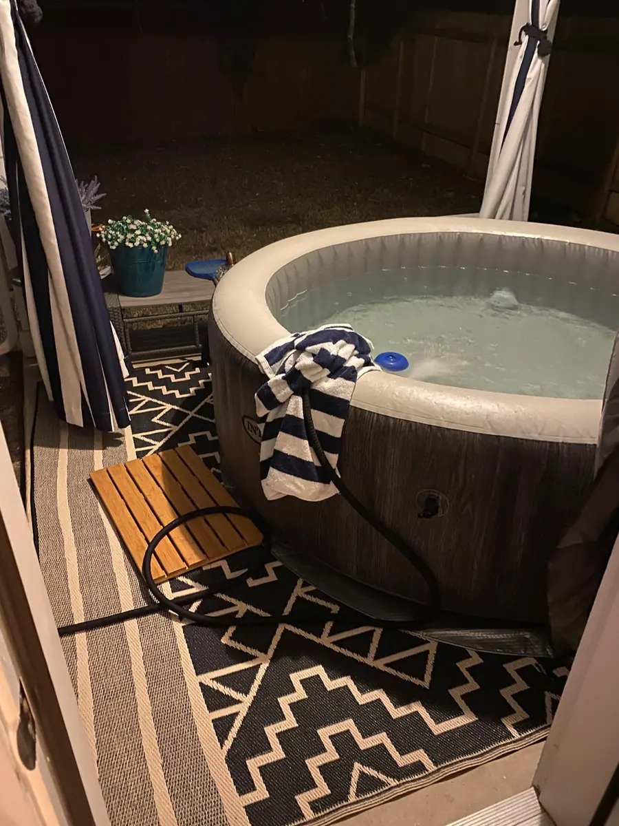 PureSpa Greywood Deluxe lit at night on a back patio