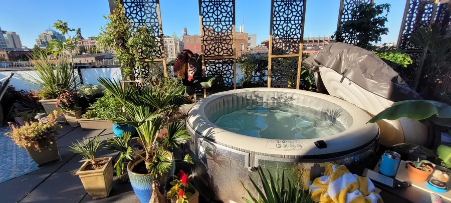 PureSpa set up on a city rooftop patio surrounded by plants